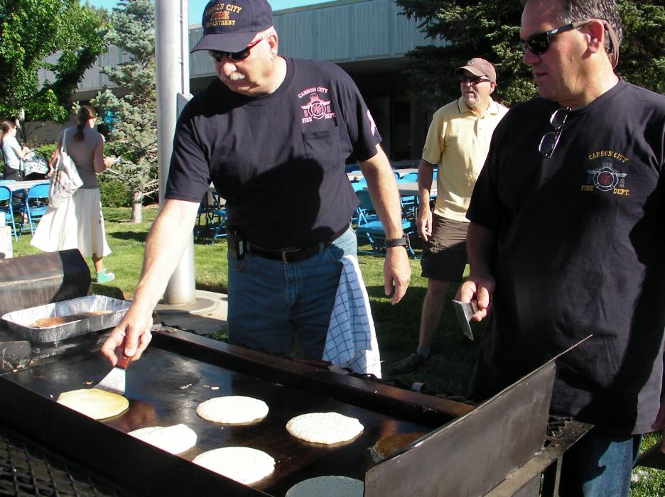 Tom Tarulli, Assistant Fire Chief, and Carson City Fire Chief Bob Schreihans flip hotcakes at the library.