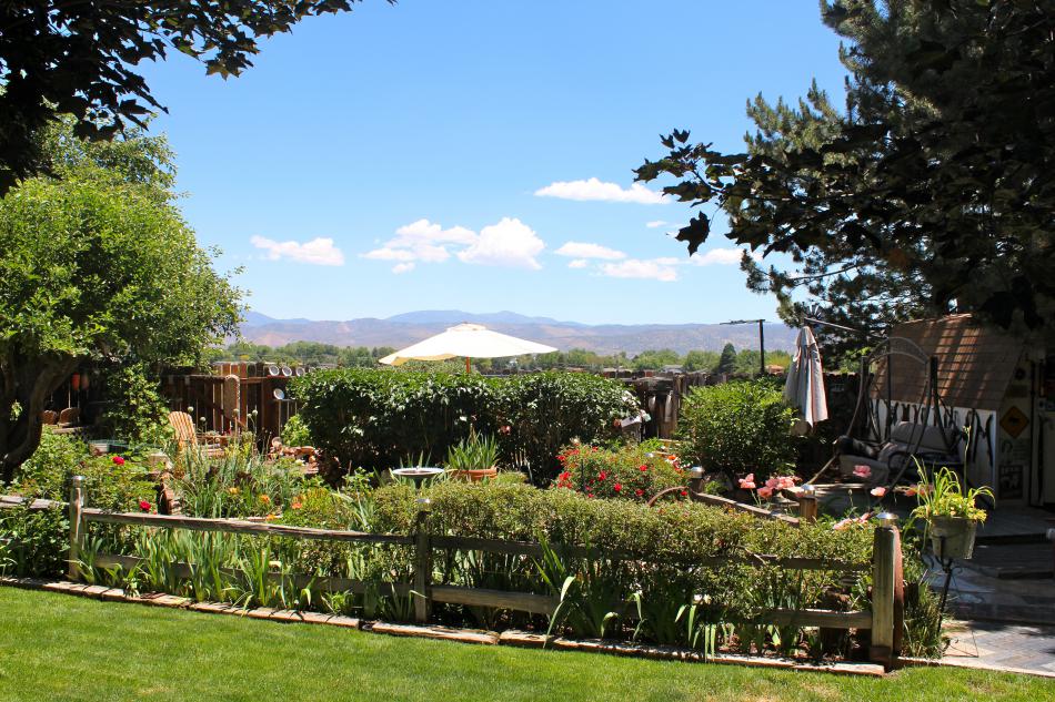 A garden overlooks a beautiful view of the hills and mountains.