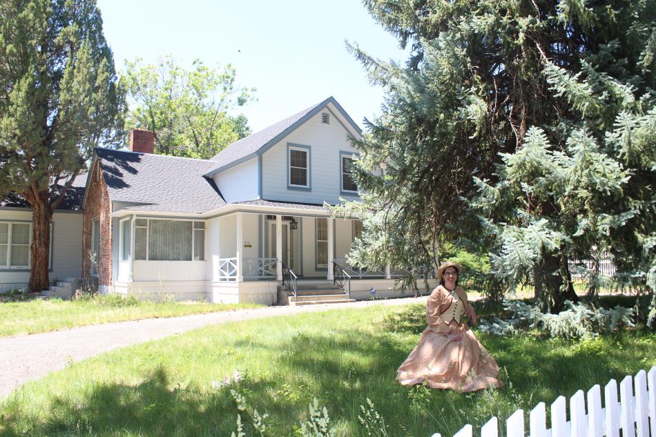 A volunteer poses with Hannah Clapp's historic home.