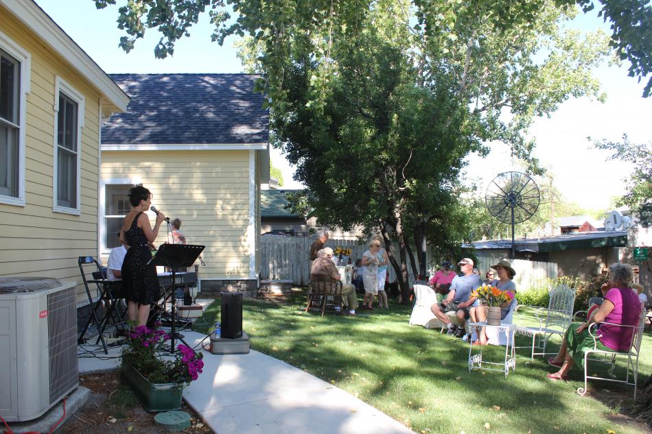 Community members and gardeners catch up over glasses of wine.