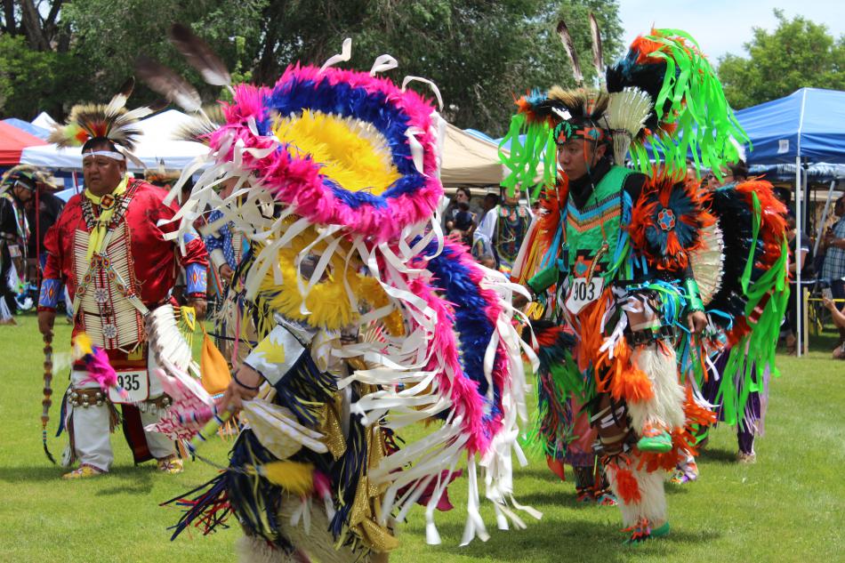 Clad in beads, feathers and bells, dancers of all ages dance through the arena