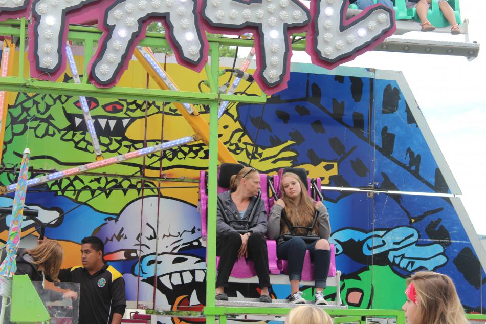 Mom and her daughter are sad to get off the carnival ride.