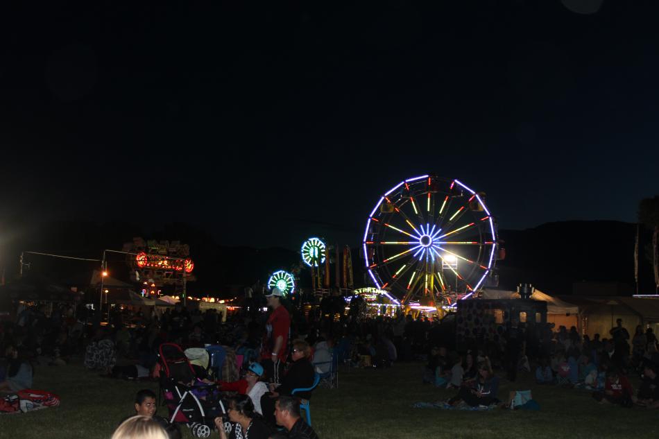 Lights from the ferris wheel and other rides shown through the night.