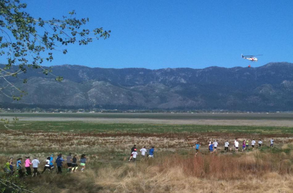 A Nevada Division of Forestry helicopter drops water to signal the start of Washoe County’s Wildfire Awareness Run in May.