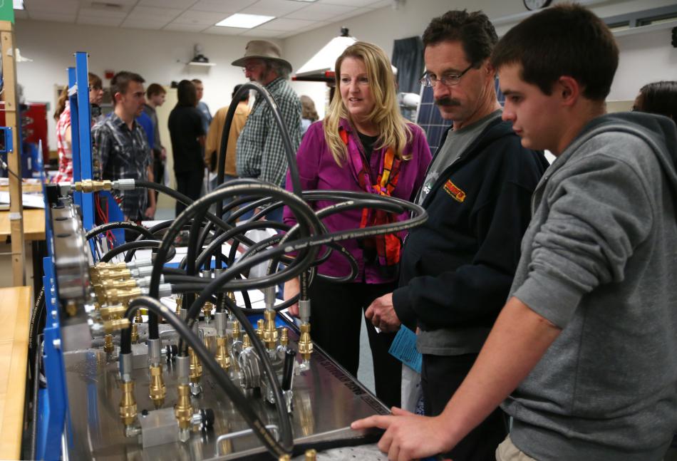 WNC Professor Emily Howarth, left, with Skip and Garret Nicholson in the Applied Industrial Technology laboratory. 