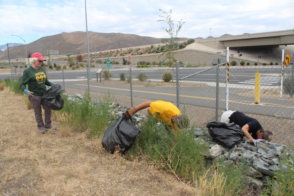 Volunteers work together on areas thick with trash.