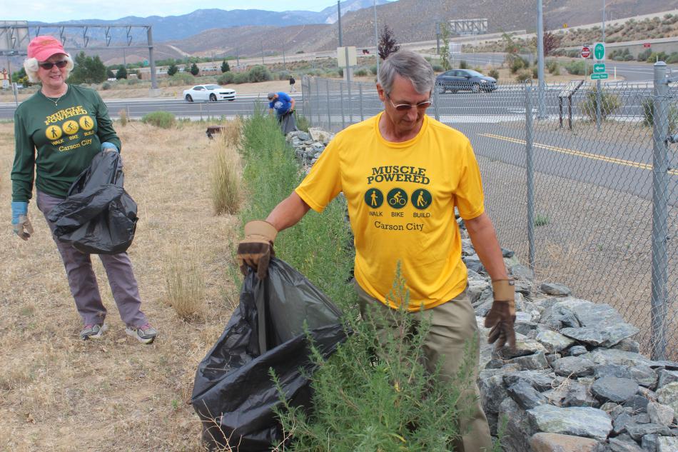 Muscle powered volunteers help each other on thick trash areas.