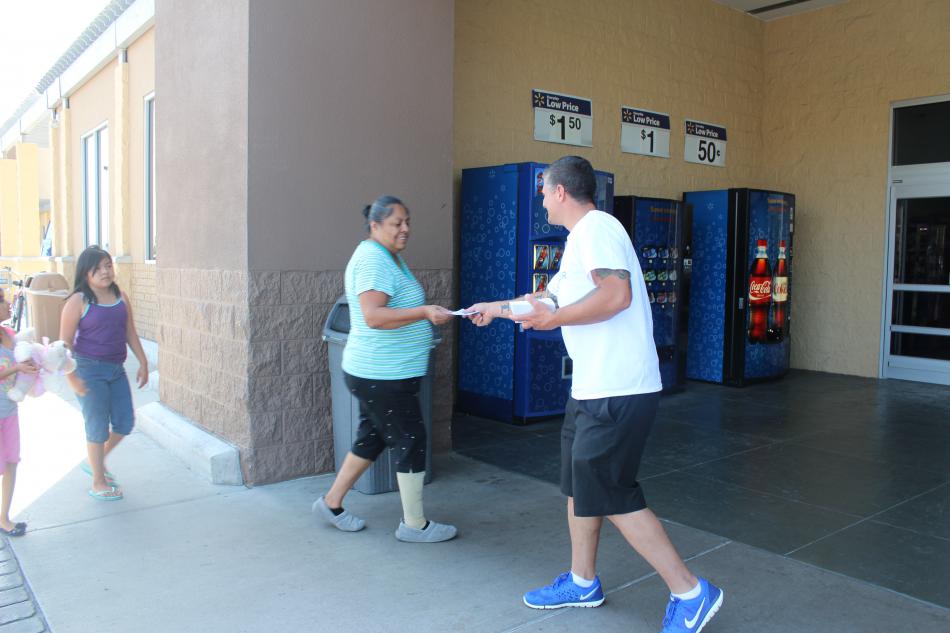 Volunteers pass out flyers to encourage people to buy packages in Walmart to donate