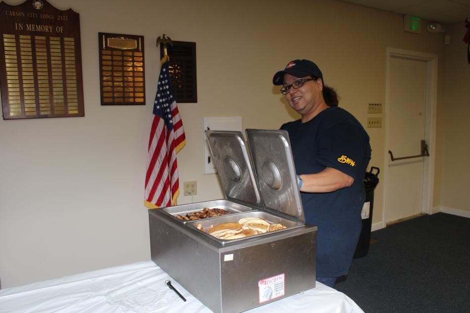 Lilly Leon-Vicks gets ready to serve sausage and pancakes