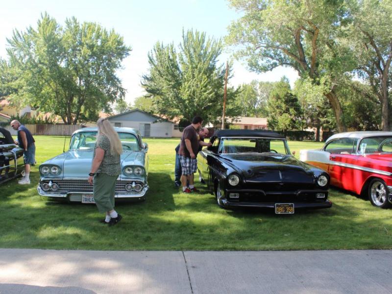 A group of freshly polished cars are admired