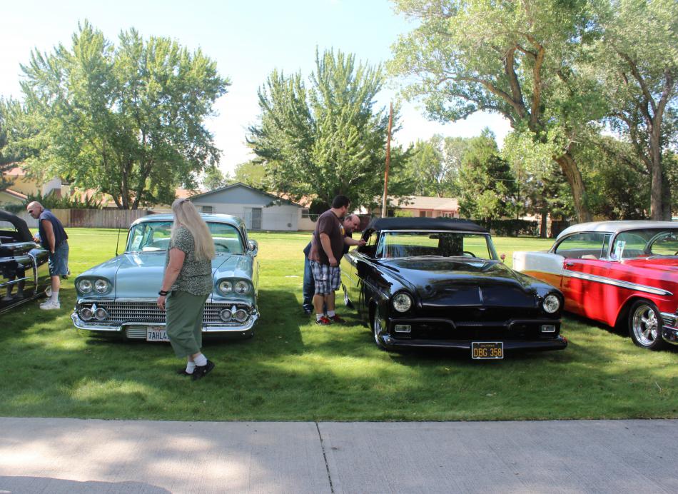 A group of freshly polished cars are admired