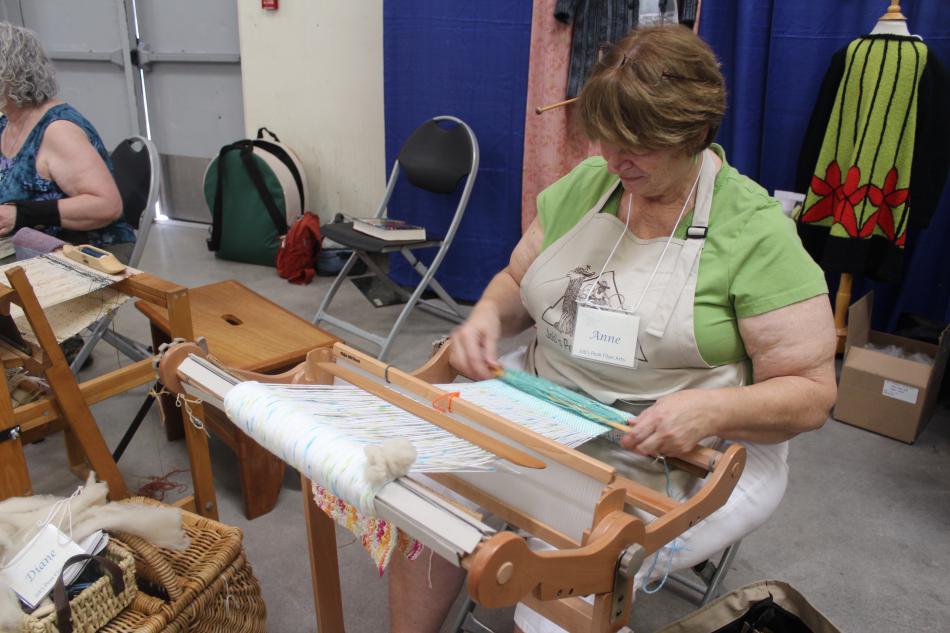 Anne from Job's Peak Fiber Arts show other guests how to weave