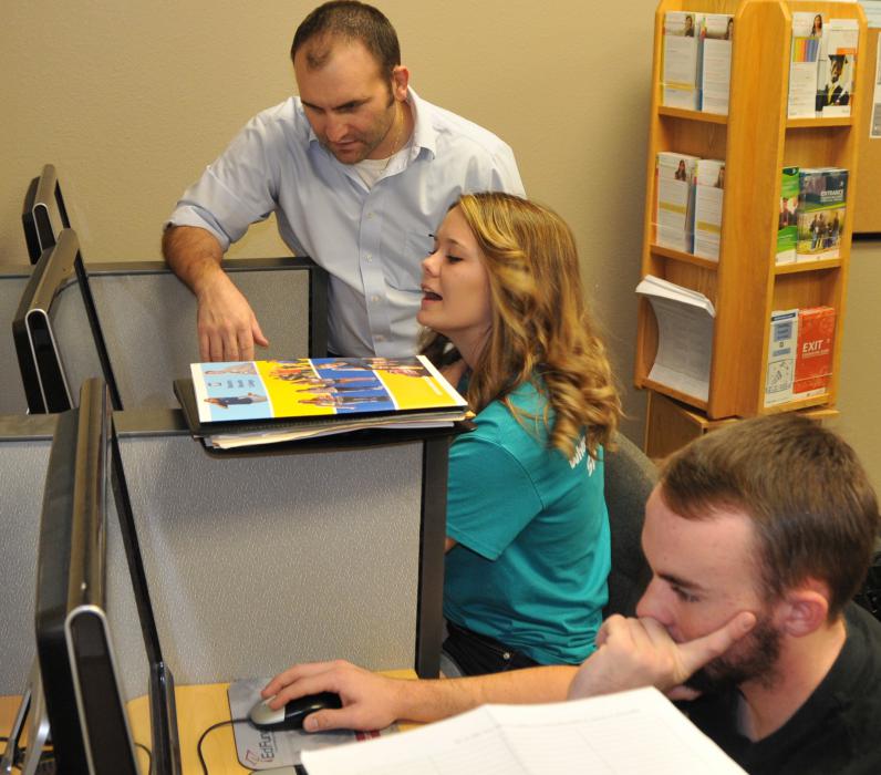 WNC Financial Aid Director J.W. Lazzari, assists Danica Corkern and Anthony Farina.