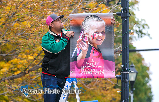 James Salanoa, with the Carson City Visitors Bureau, hangs a banner in the downtown area. Cathleen Allison, Nevada Photo Source