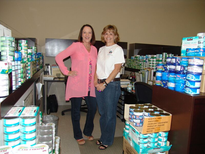 De De Rosene and Michelle Sturge at the Chase International Damonte Office surrounded by cans of tuna they collected.