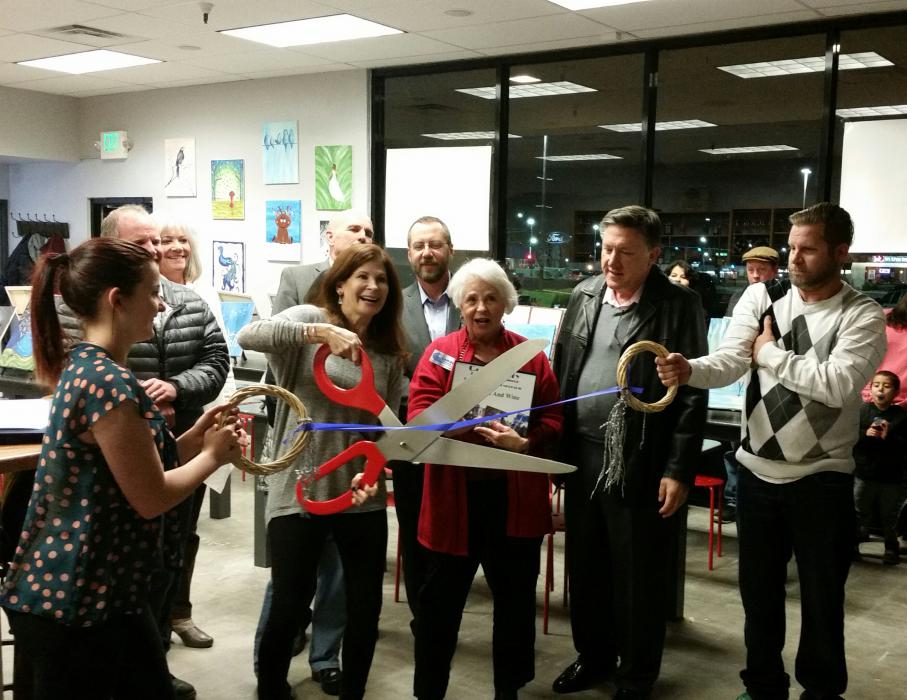 Diane Basche, owner of Mona Lisa and Wine, cuts the ribbon at the grand opening on Monday.
