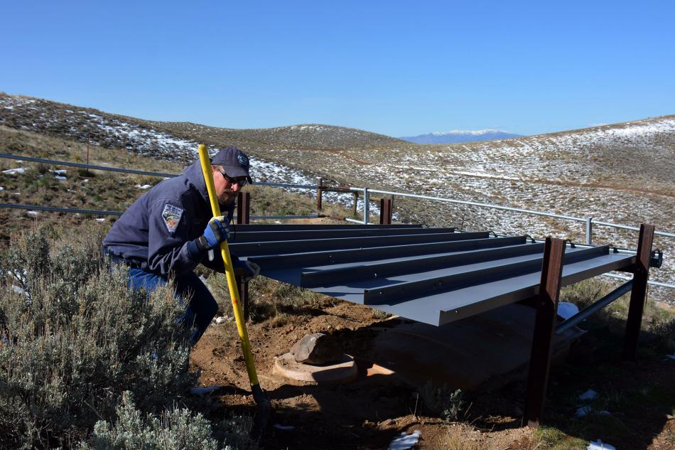 Clint Garrett works on a water tank. Photo courtesy of Nevada Department of Wildlife. 