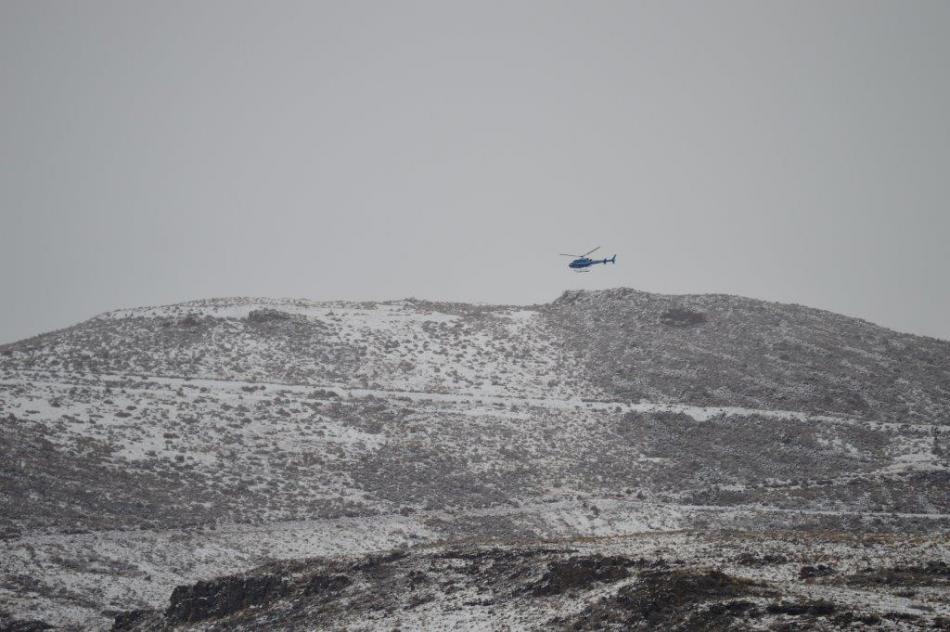 A helicopter surveys the area where the victim's vehicle was discovered. Photo by Brett Fisher