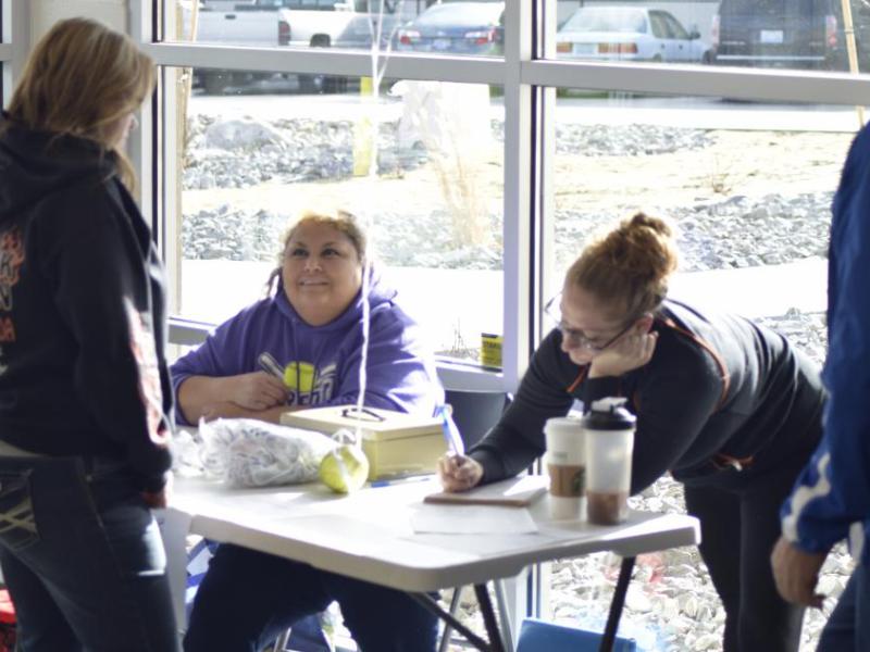 Tonya (left), Bailee (right), and Chris (not pictured) help parents with signing up