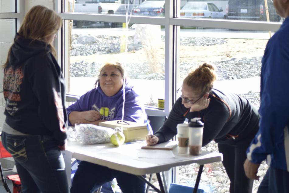 Tonya (left), Bailee (right), and Chris (not pictured) help parents with signing up