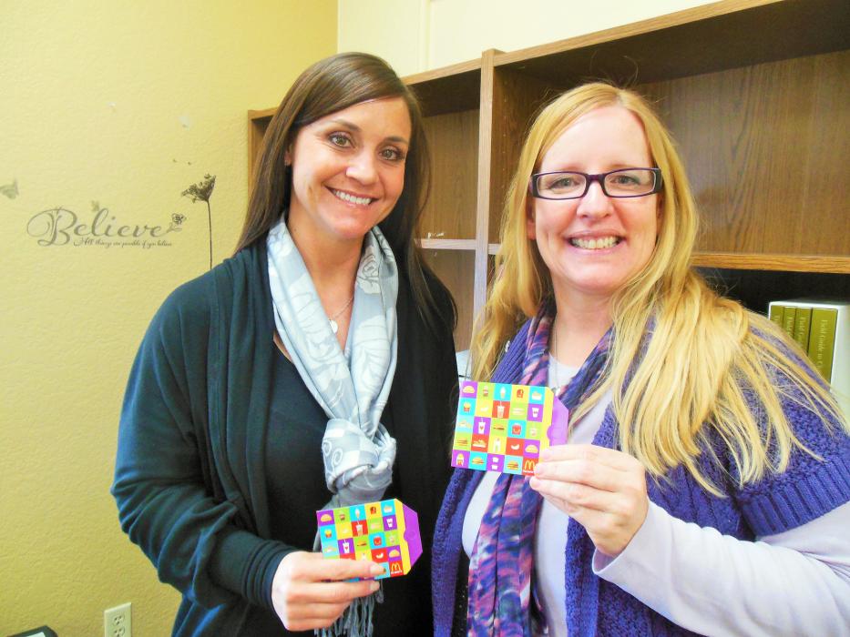 Nicole Abowd of Kassity Management Group (left) and Lori Nichols, LSW, of Nevada DCFS show the McDonald's gift card donations.
