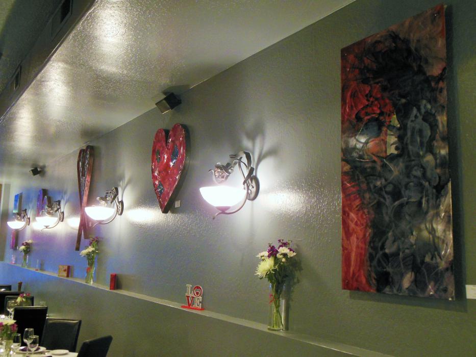 Artwork from Artsy Fartsy gallery displayed along the wall of Mystique's dining room.