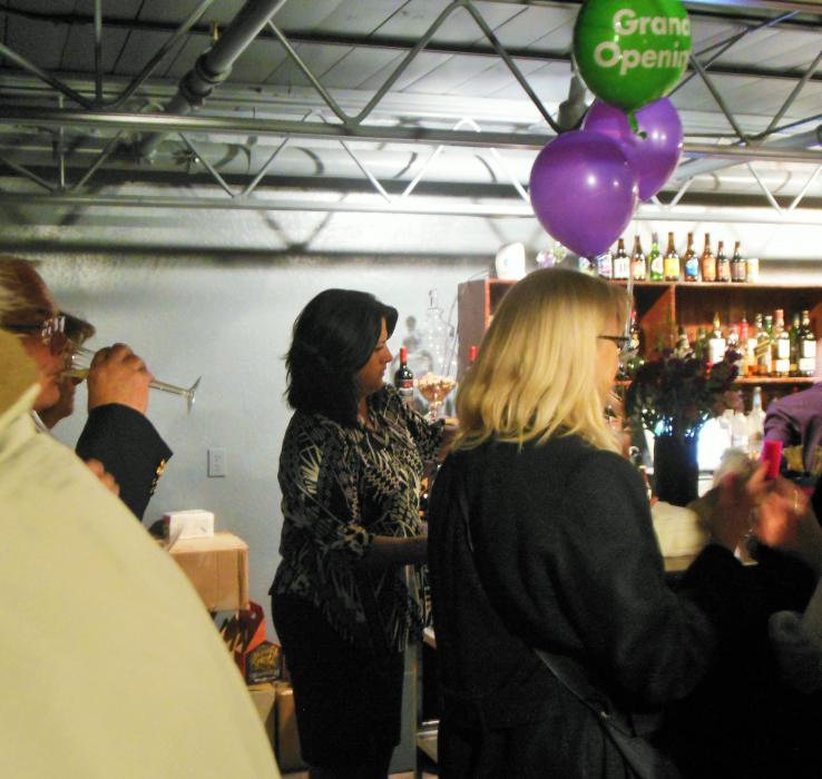 Yvette Barrett (center) pours champagne in flutes for guests attending her restaurant's grand opening celebration Tuesday night.