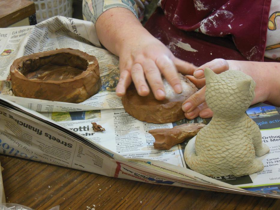 A pottery artist shapes clay in the studio at Carson City Pottery.