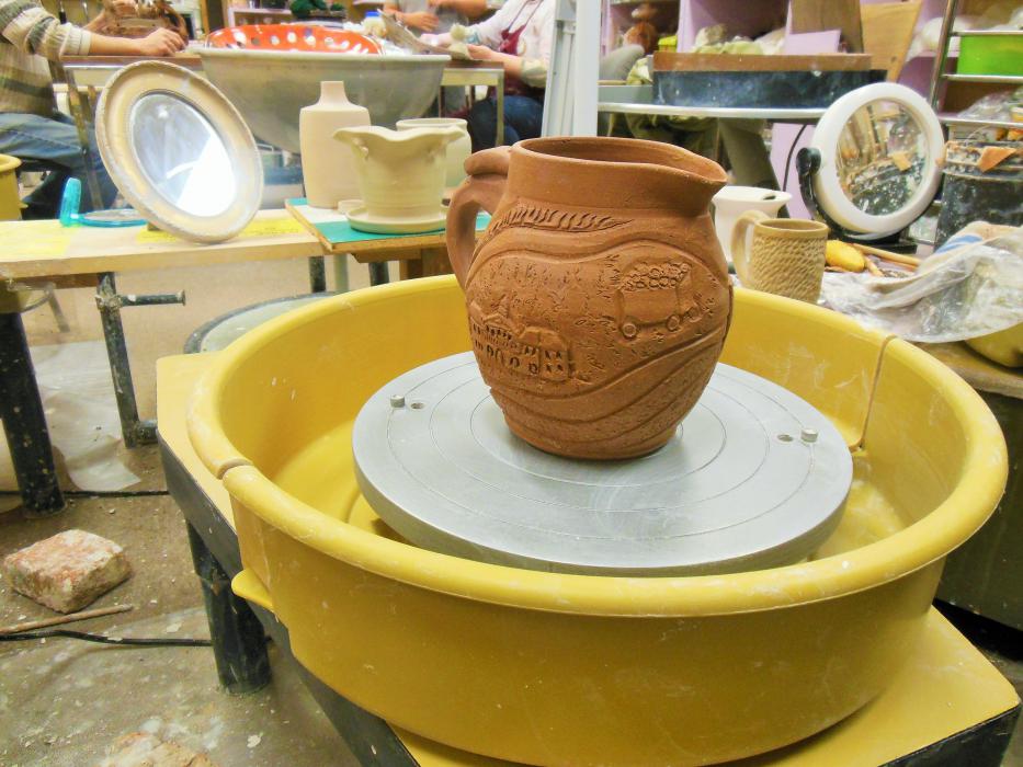 One of Robin McGregor's unfinished original pieces on a pottery wheel, depicting scenes from Nevada.