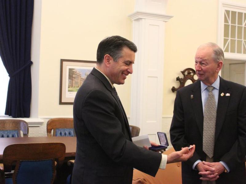 Gov. Sandoval admires the commemorative medallion presented by Bud Southard of the U.S. Navy League, Carson City Council.