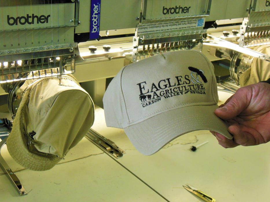 Billow shows his automated stitching machine producing hats for the Eagles & Agriculture event.