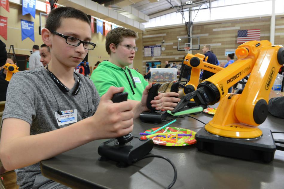 Anthony Aguilar, left, and Jack Wilson work with robotic arms at Eagle Valley's STEM Night. Photo by Tim Dunn