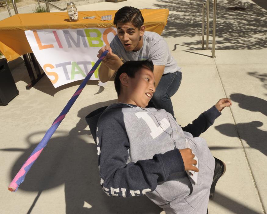 Adrian Barrera, 18, Carson City, reacts as the tallest youngster in the group next to Jovani Arroyo, 10, in the limbo contest.