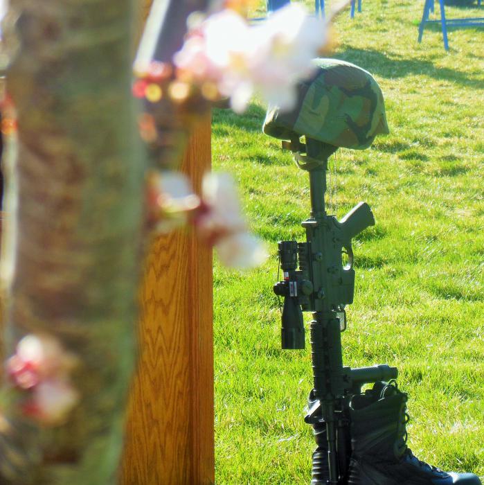 Spring blossoms in the foreground and the fallen soldier marker displayed Saturday at Mills Park.