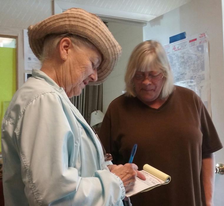 RCIL volunteer Edwina Wiersma (left) signs a donation receipt for the Elks Club Friday for fresh produce donations.