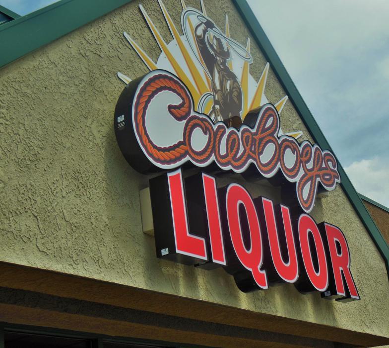 Storefront sign at Cowboys Liquor, 444 E. William Street.