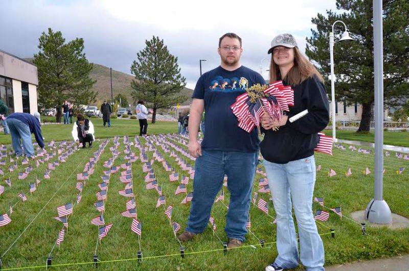 Josh Patterson and Ruby Herman place flags for Veteran Suicide Awareness Walk Saturday at the WNC main campus in Carson City.