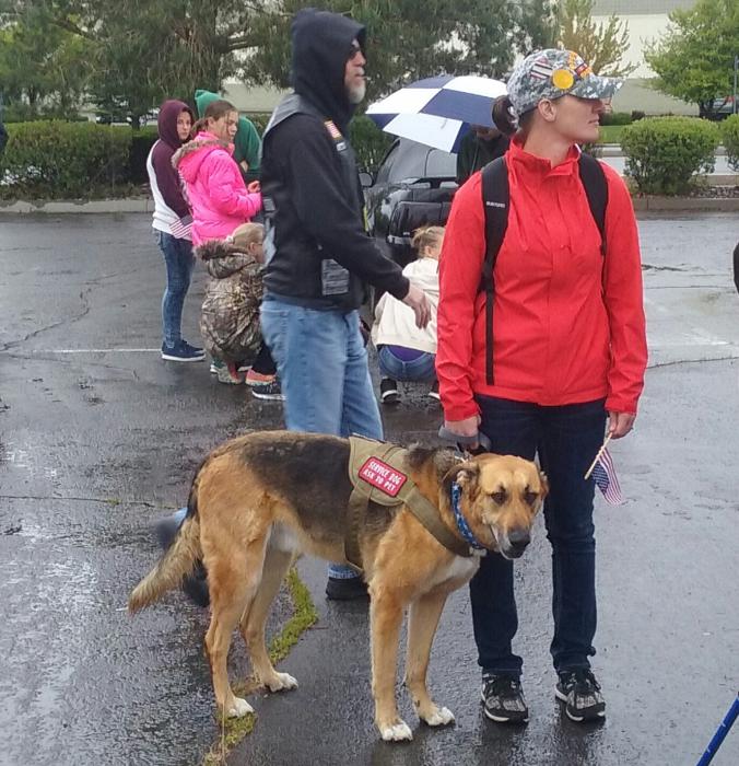 U.S. Army veteran Sarah Goulart with her service dog Chaos await the start of Saturday morning's suicide awareness march.