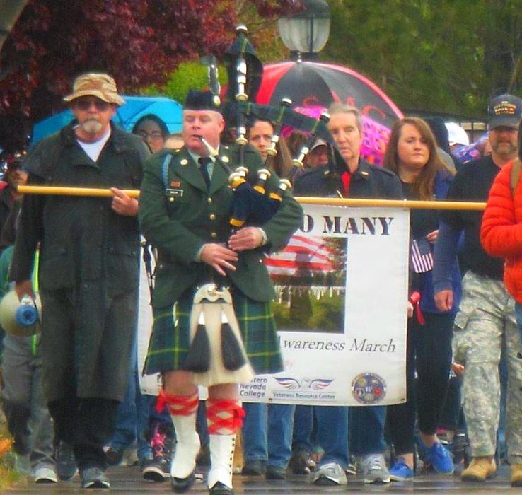 A bagpiper leads the procession Saturday up W. College Pkwy during the Veterans Suicide Awareness March.