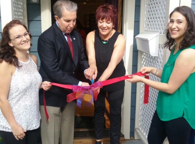 Deb Kytle (with scissors) cuts the ribbon to Chi's new home with Mayor Bob Crowell, Gabriela Ortiz and Jacquie Holocker.