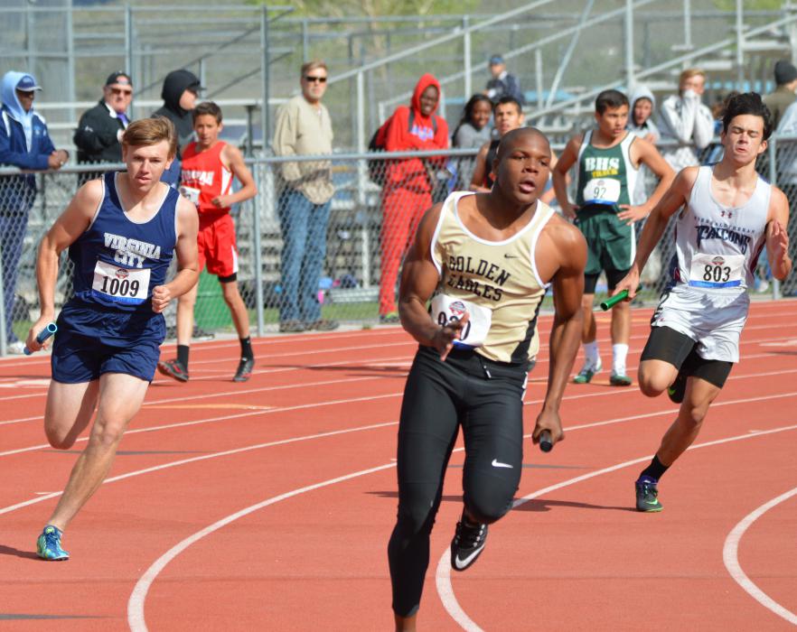 Sierra Lutheran (inside lane) and Virginia City (outside lane) runners compete in the boys Division IV 4x200 relay Friday.