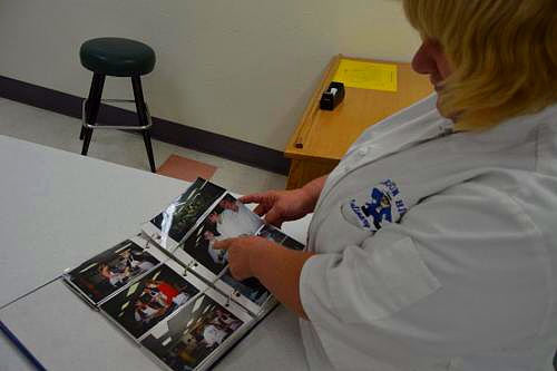 CHS Culinary Arts teacher Penny Reynolds flips through a photo album of memories and former students.