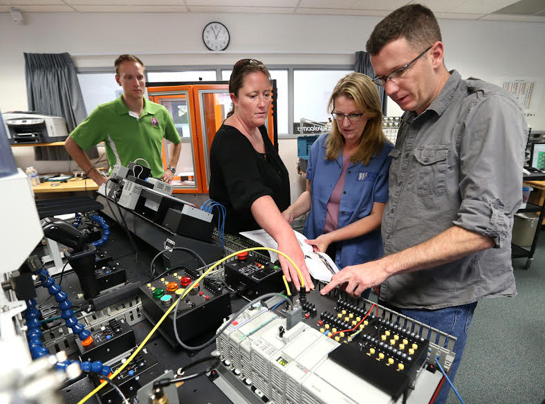 Brendan Flayer, Lindsay Moore, Professor Emily Howarth and Matt Anderson work in the WNC Carson City industrial technology lab.