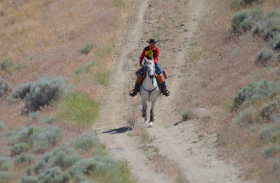 Photo by Lisa Fisher. Diane Garland and Louie climb the hill toward Mound House.