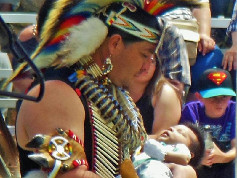 Photo by Brett Fisher. A father and his infant dance during the grand entry.