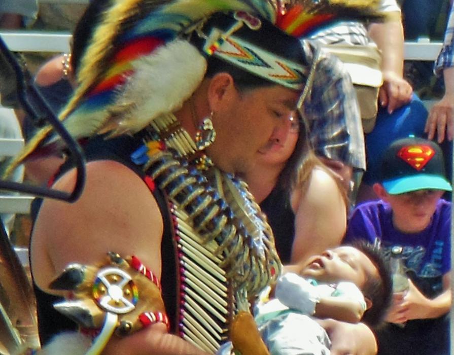Photo by Brett Fisher. A father and his infant dance during the grand entry.