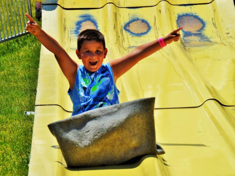 A boy is jubilant after completing his ride down the giant slide Saturday.