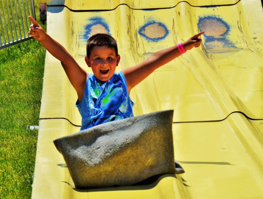 A boy is jubilant after completing his ride down the giant slide Saturday.