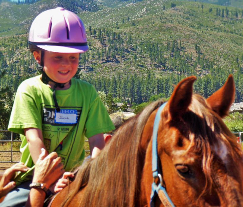 Jacob from the Boys and Girls Club of Western Nevada on Rose, a mustang.