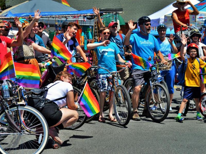 Photo by Brett Fisher. Parade bicyclists wave to supporters in the parking lot of Carson Hot Springs Resort Saturday.